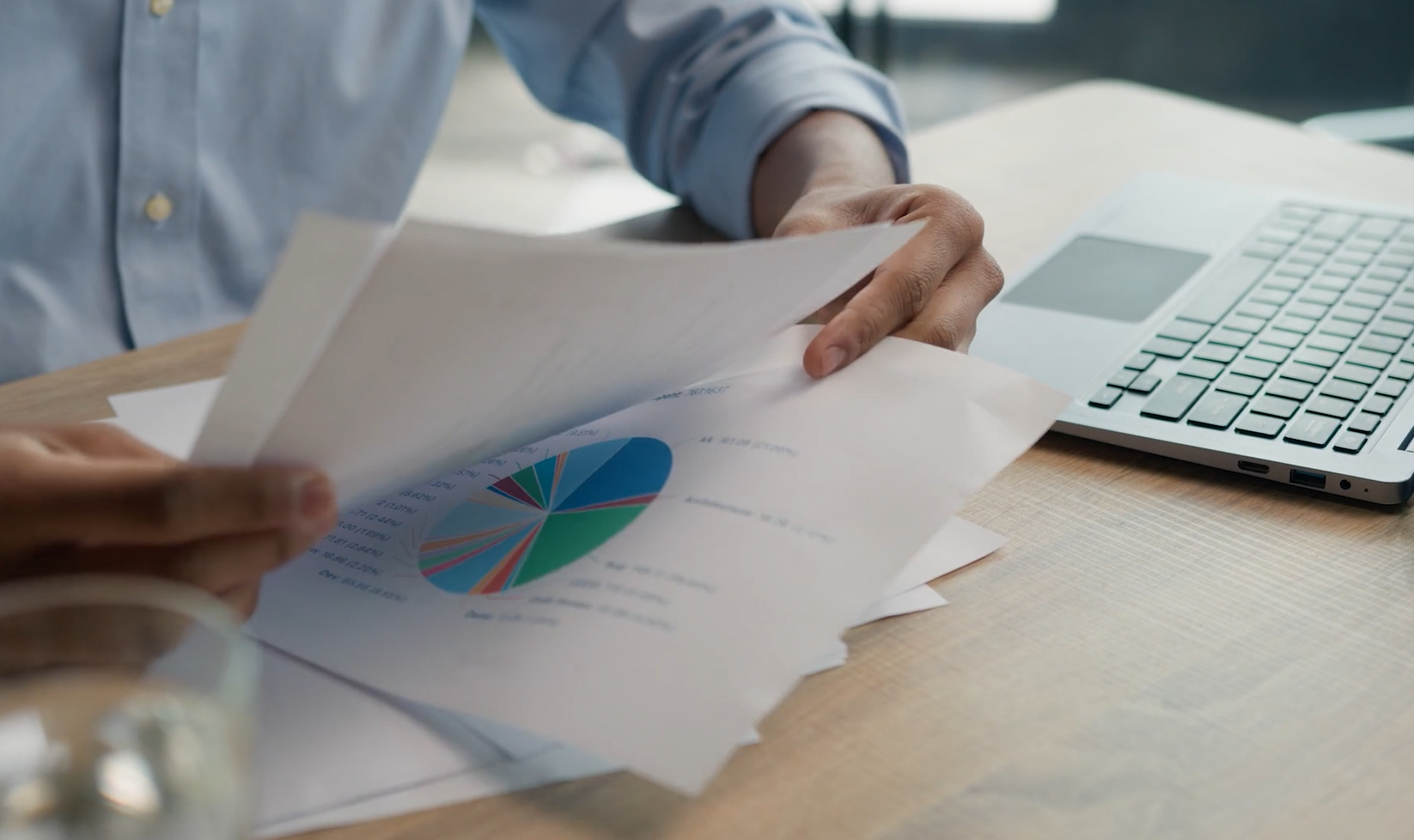 person at a desk looking through charts on papers